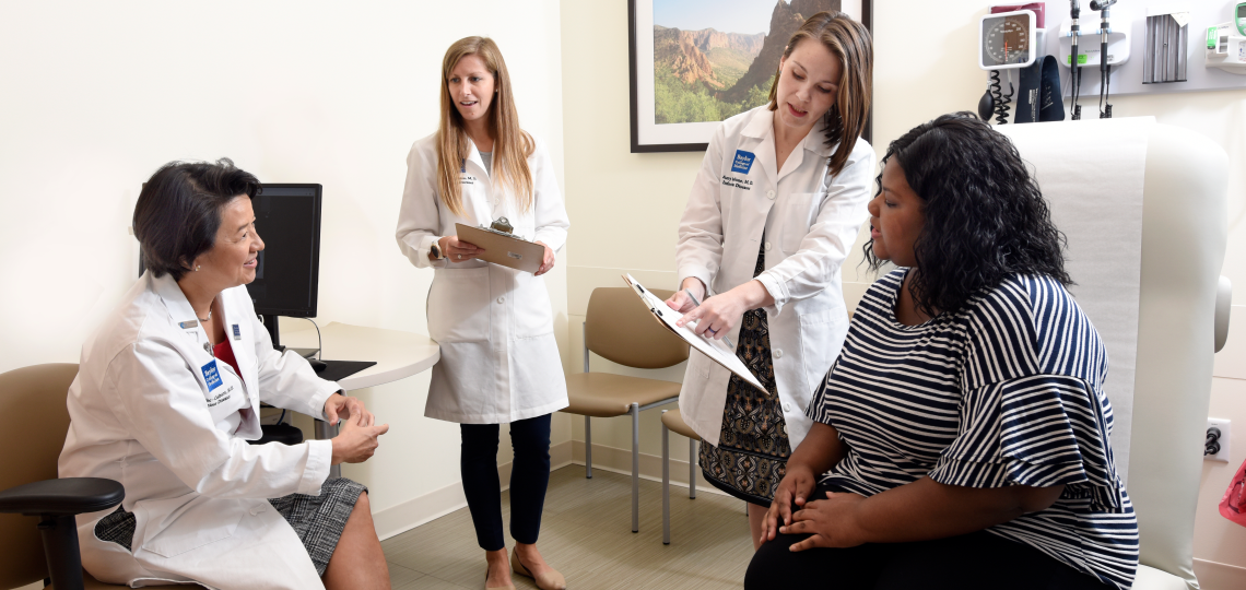 Three doctors discussing a care plan with a patient.