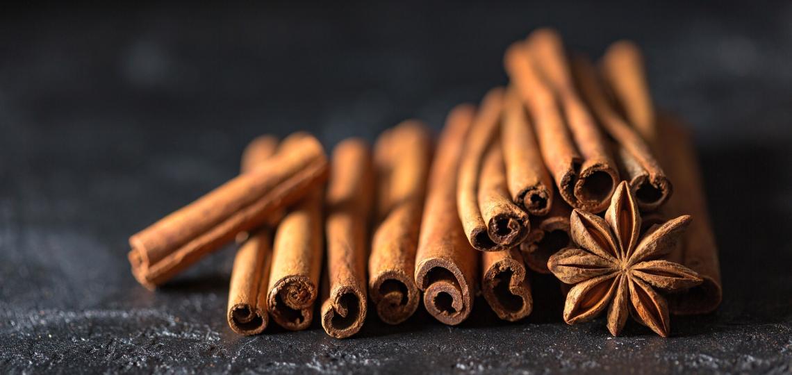 Stack of cinnamon sticks and star anice spice on a black background
