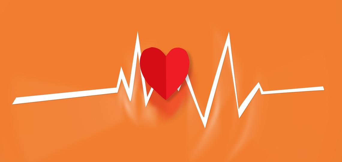 Red heart on orange background with white heart beat graph lines. 
