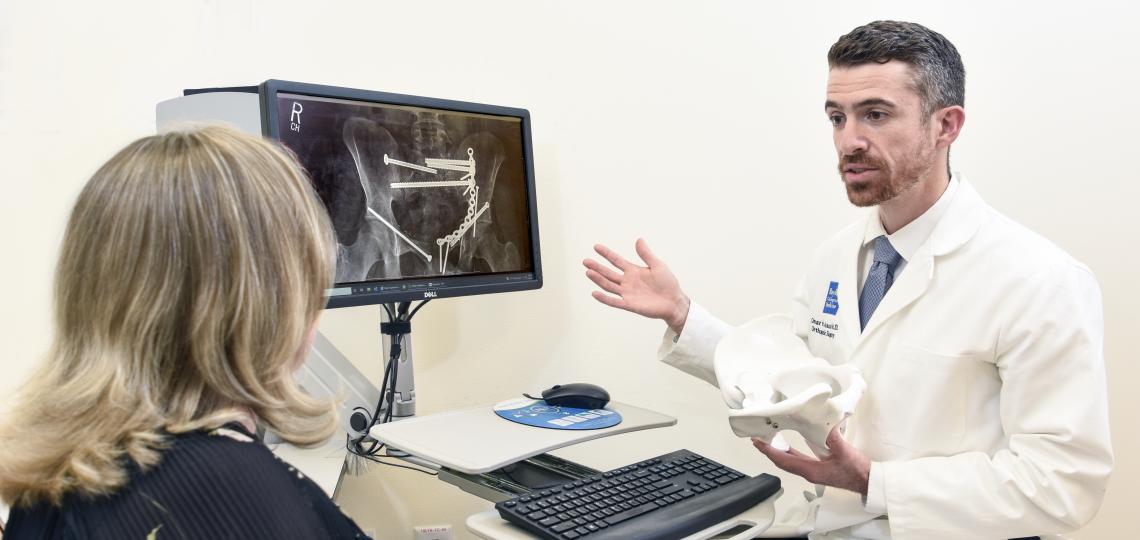 A doctor consulting a patient with an orthopedic x-ray.