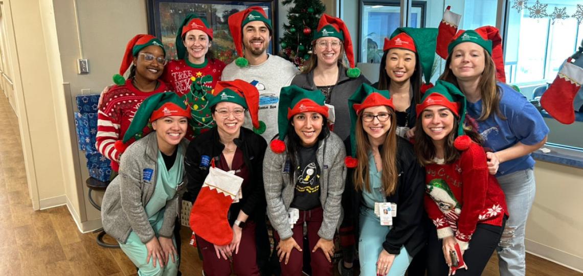 Residents in a group pose wearing Christmas hats