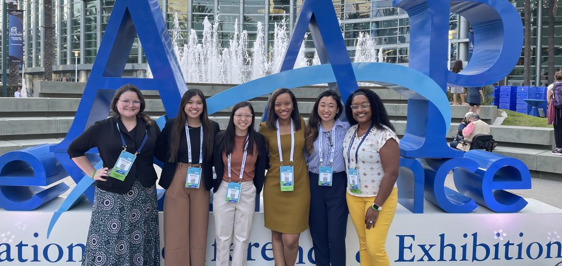 Residents in front of a large AAP sign and a fountain