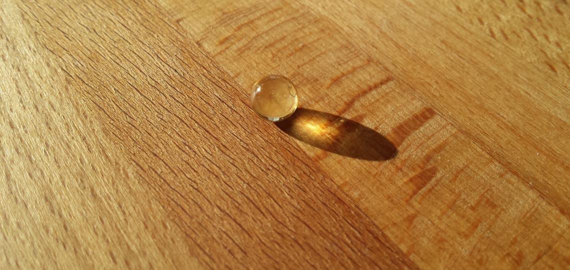 Photo of a vitamin D pill on a wooden table top. 