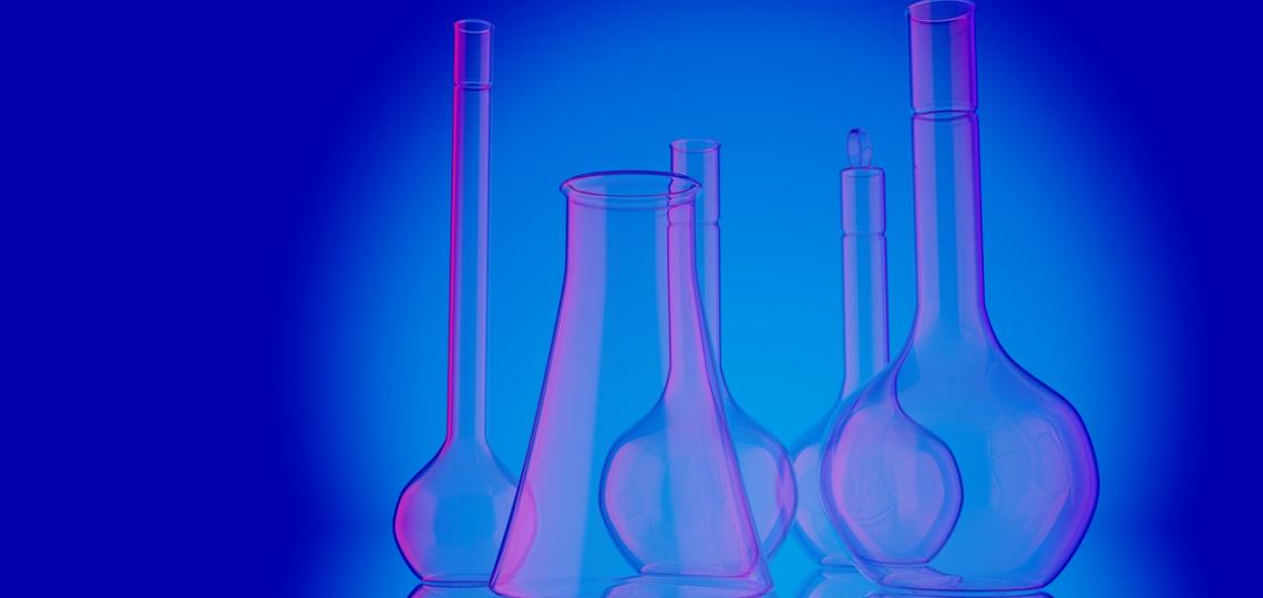Photo of different sized beakers with blue and pink lighting, represents a general idea of lab work.