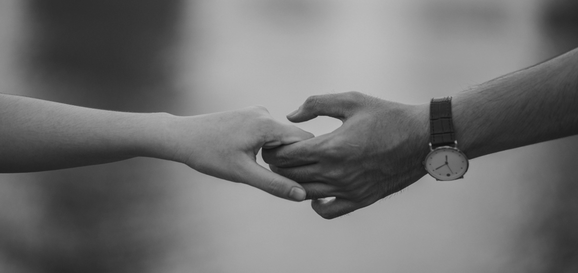 black and white photo of handholding 