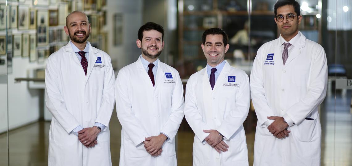 four doctors in white coats smiling