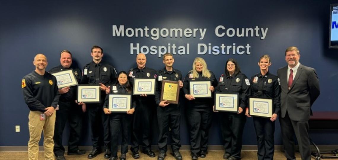 group of ems smiling and holding certificate
