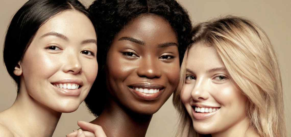 a trio of young women with smiles and clear skin