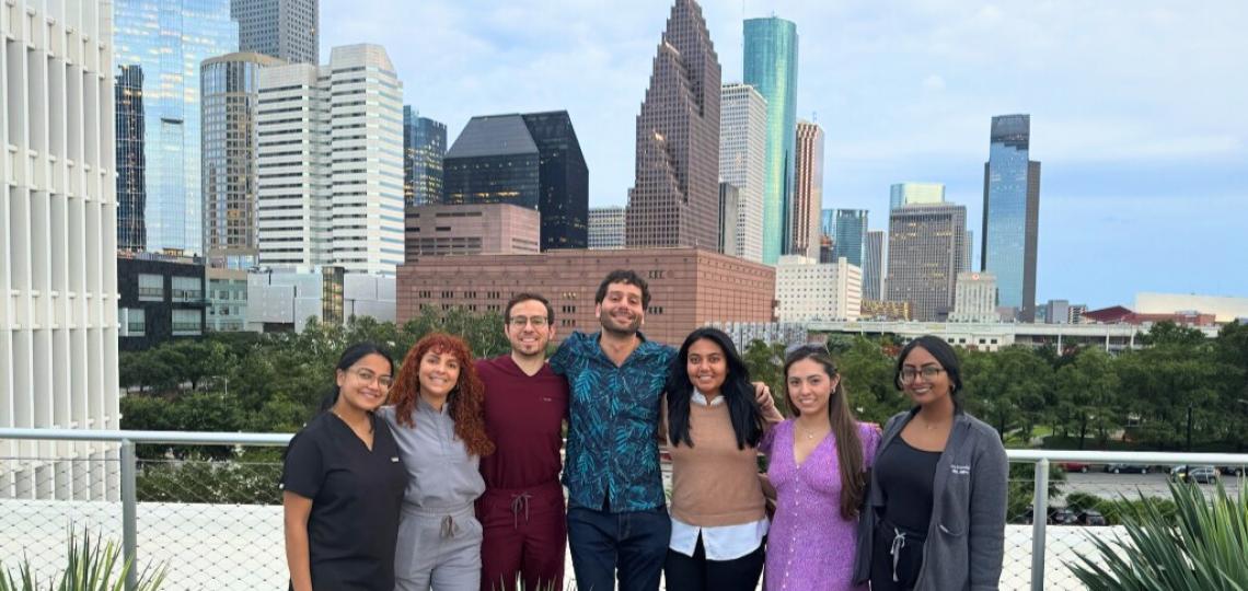 group of people smiling in front of the Houston skyline