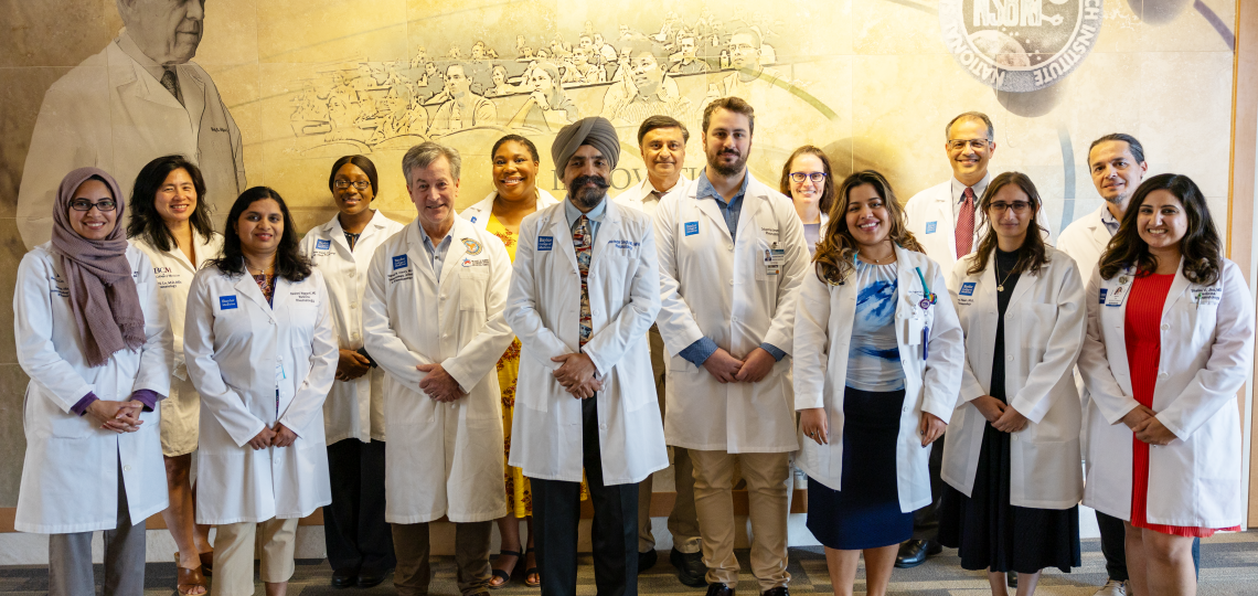 group of doctors smiling in front of a mural