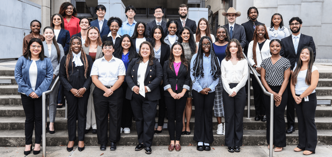 Four rows of students staggered on stairs, smiling