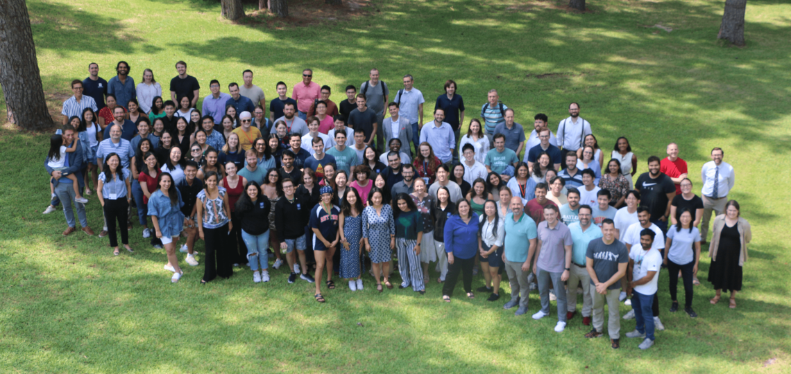 A large group posing outside, as seen from an ariel view.