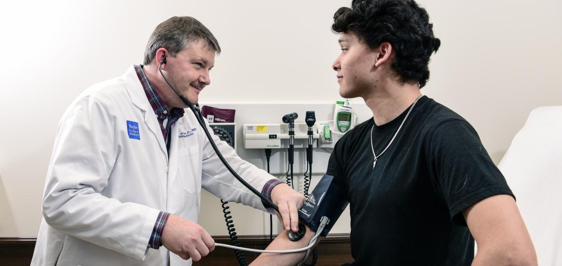 doctor performing a heart beat test through a stethescope on a patient