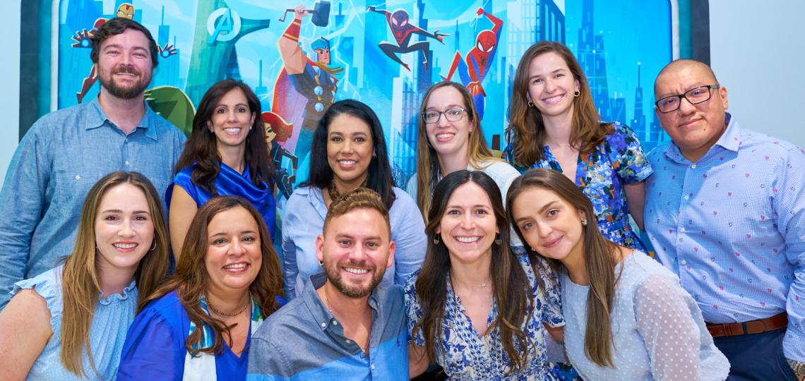 Pediatric Rheumatology Fellows standing in front of a large picture of Marvel superheroes.