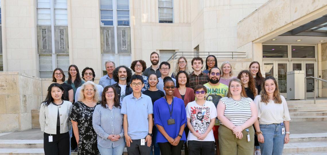 group of people standing outside on stairs, smiling