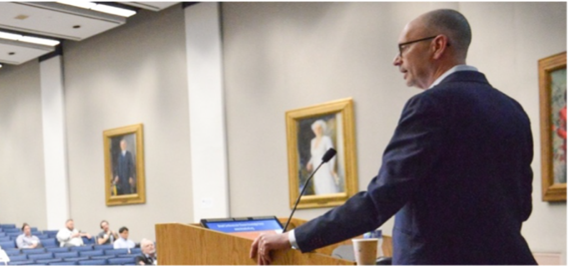 man speaking to an auditorium of people