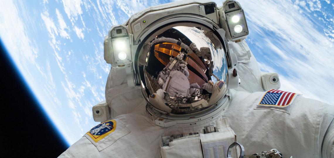 Fellow spacewalker Rick Mastracchio appears in the reflection of Astronaut's Mike Hopkins' helmet.