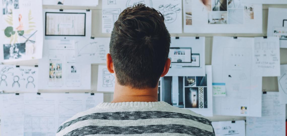 Man looking at board and thinking.