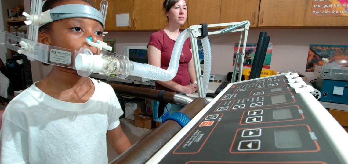Measuring a child's energy expenditure while on a treadmill utilizing one of the indirect calorimetry carts in the exercise lab of the Energy Metabolism Laboratory.