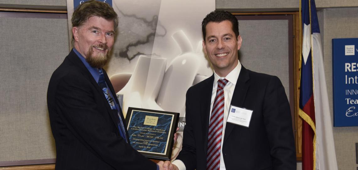 CVRI director Dr. Xander Wehrens, right, presents the Distinguished TMC Keynote Lecture Award to Dr. John Cooke, left, from Houston Methodist Research Institute