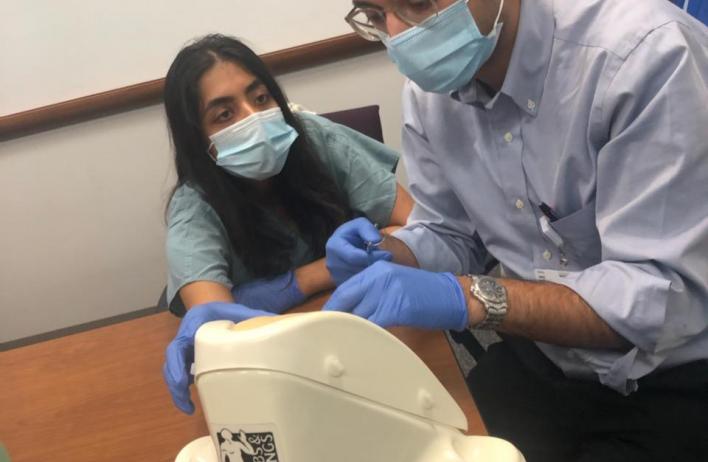 Trainees inspect a simulation model.