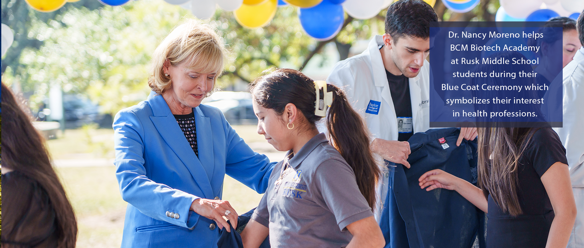 Dr. Nancy Moreno helps BCM Biotech Academy at Rusk Middle School students during their Blue Coat Ceremoney which symbolizes their interest in health professions. 