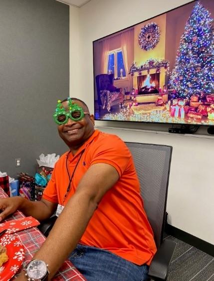 Lab Holiday Party December 2021. A lab member wears a pair of silly sunglasses.