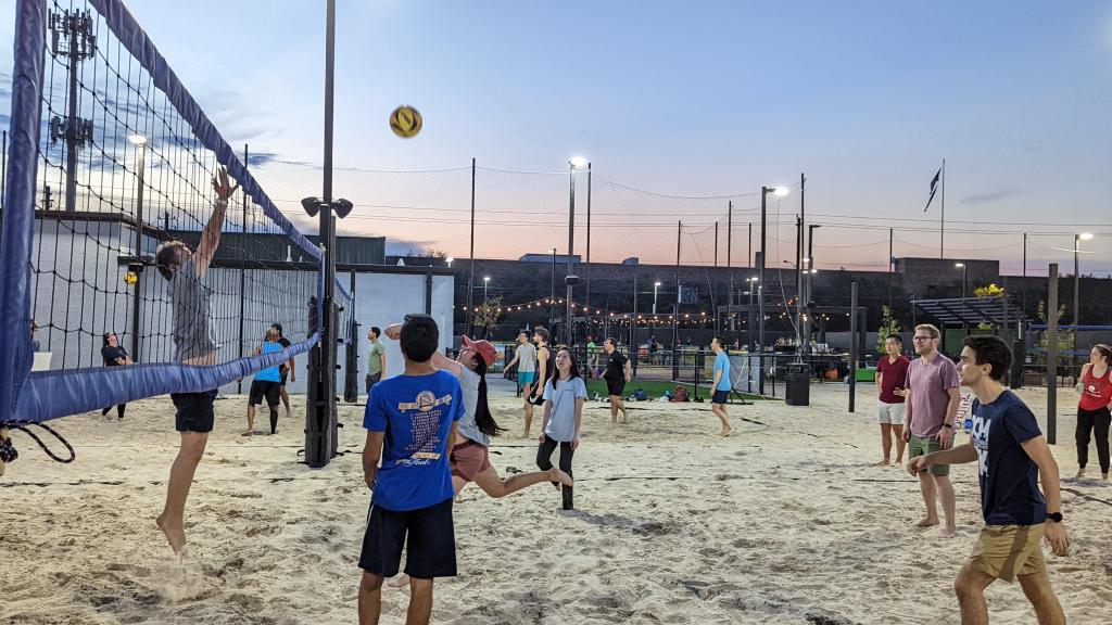 Internal Medicine residents play volleyball on a sandy pitch