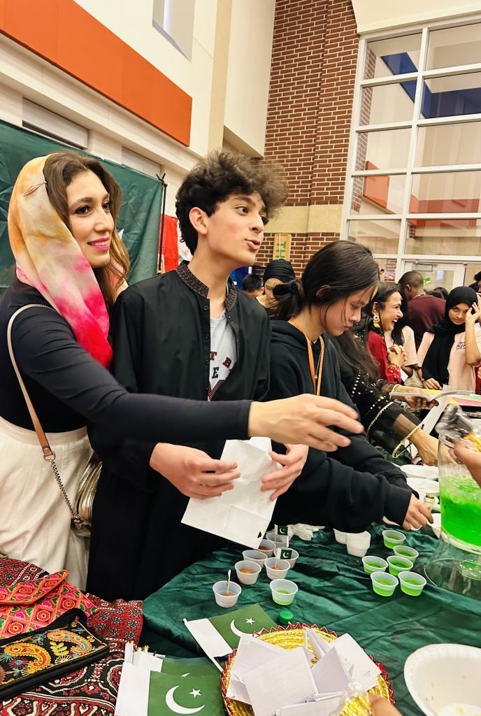 Dr. Pirzada and son representing Pakistan by passing out food and drinks at school's International Festival Night.