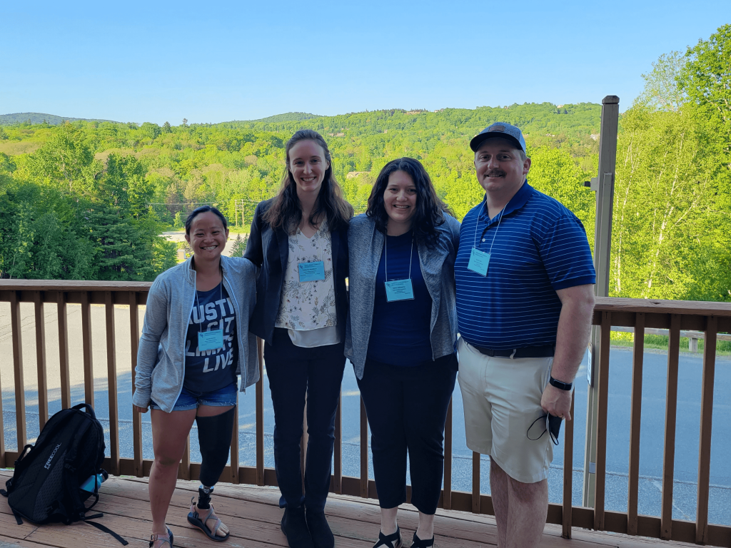 Four lab members standing outside in Dover, Vermonet during the 2023 Gordon Research Conference.