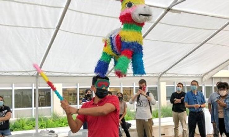 IMSD trainees take turns hitting a piñata at one of our program events.