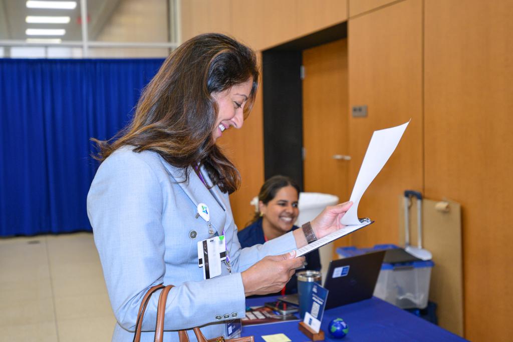 Woman smiling and looking at a clipboard