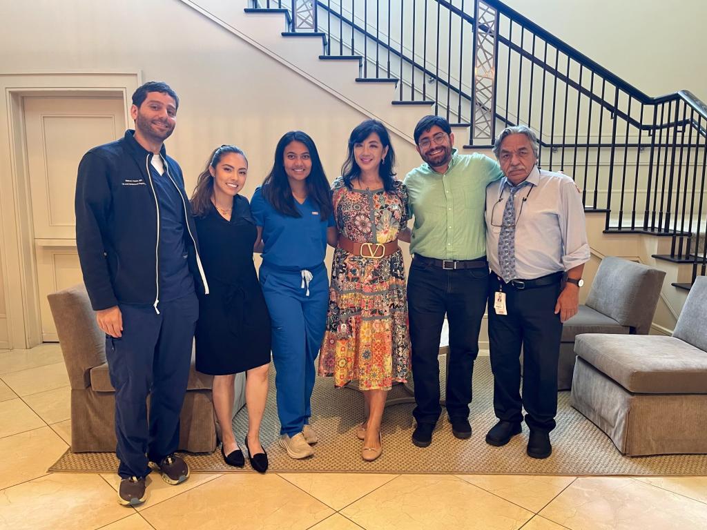 group of people smiling in front of staircase