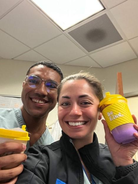 two people smiling with coffee drinks from la la coffee