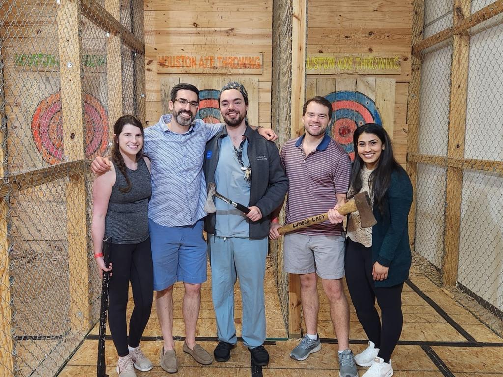 small group of people smiling at ax throwing venue