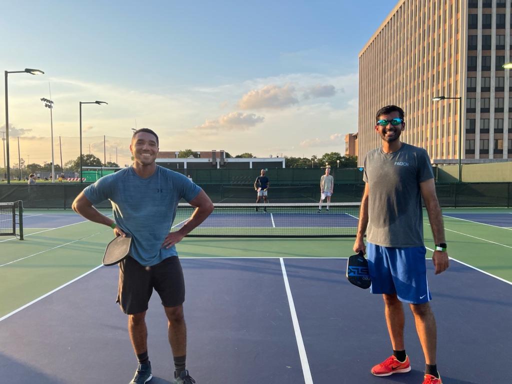 two people smiling on a tennis court