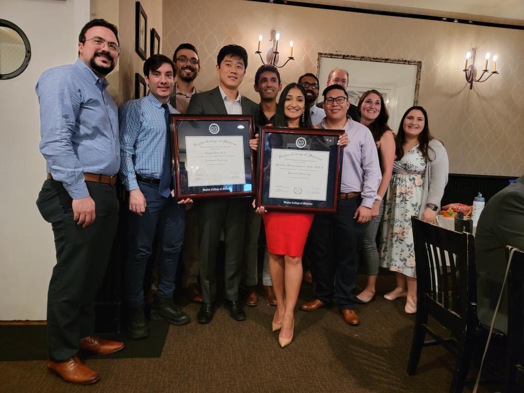 group of people holding two awards plaques