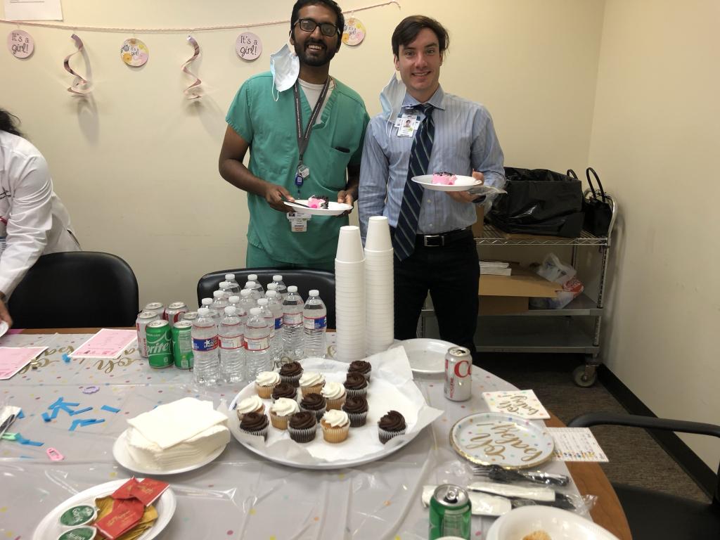 two people smiling and enjoying cupcakes