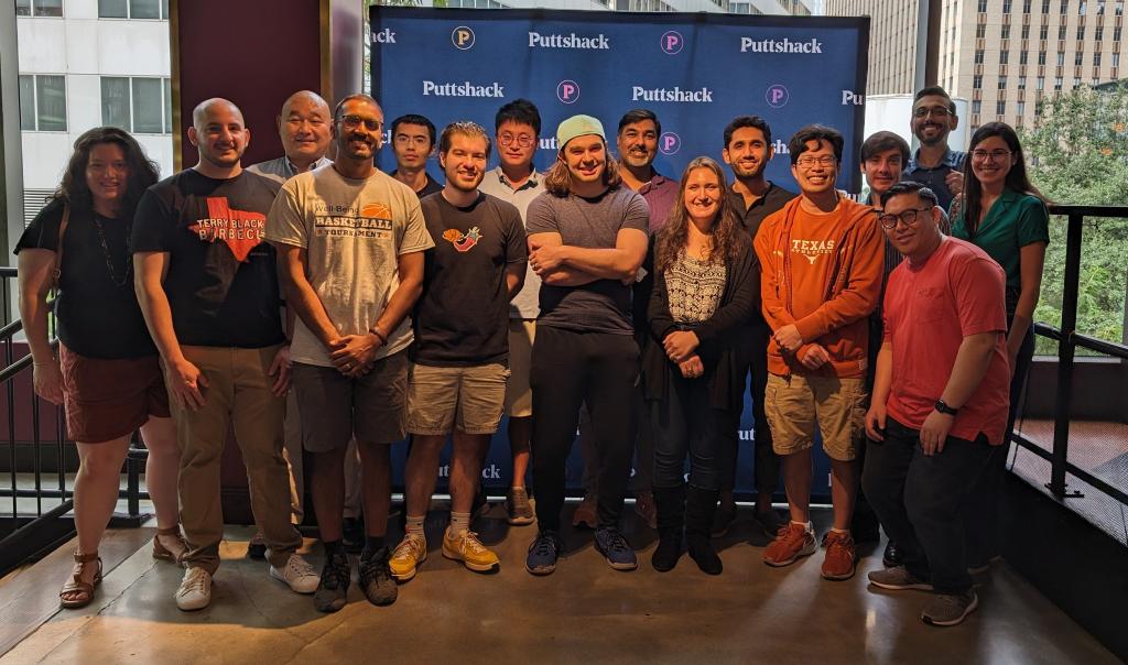 residents smiling in front of puttshack sign