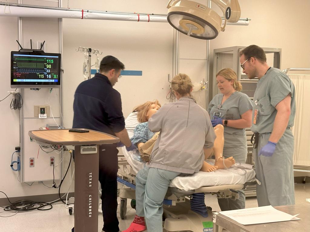 OB/GYN residents examining a fake pregnant doll