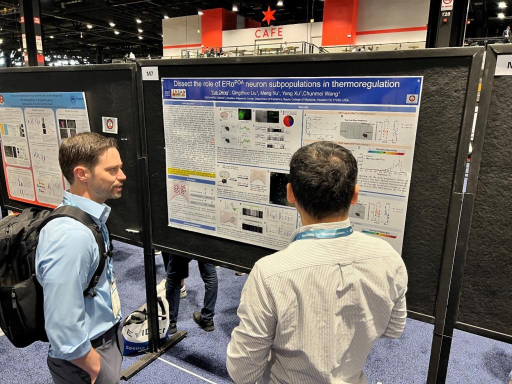 two men looking at a poster at the 2024 SfN