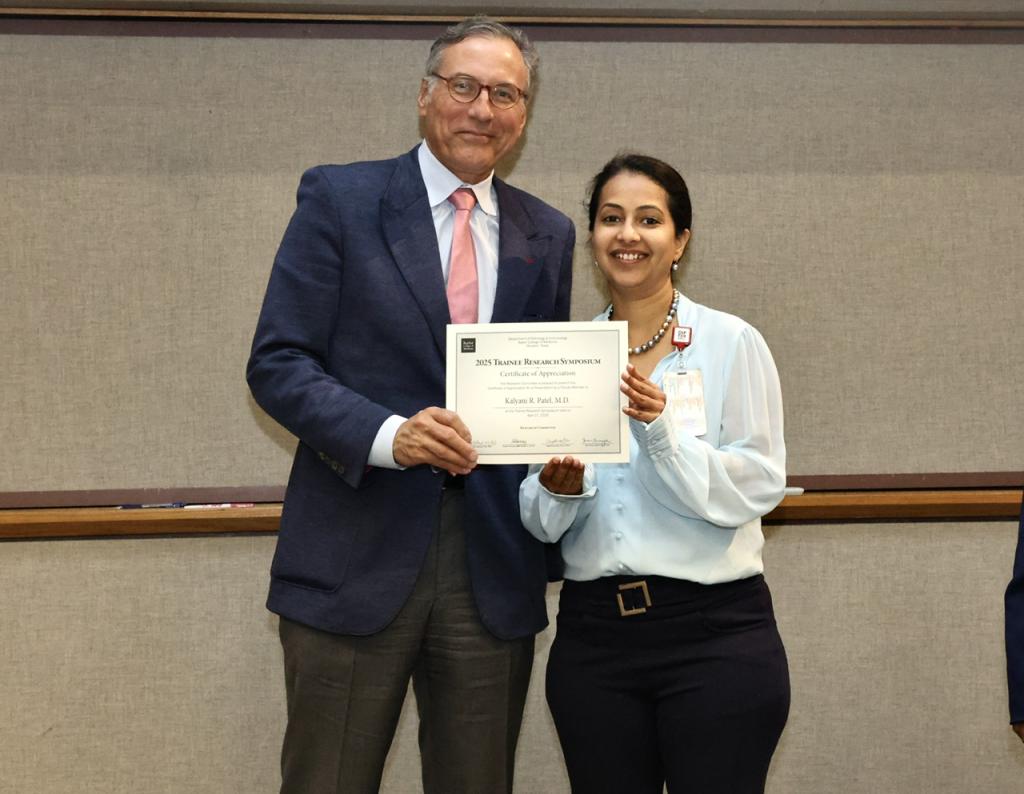 two people smiling together and holding a certificate