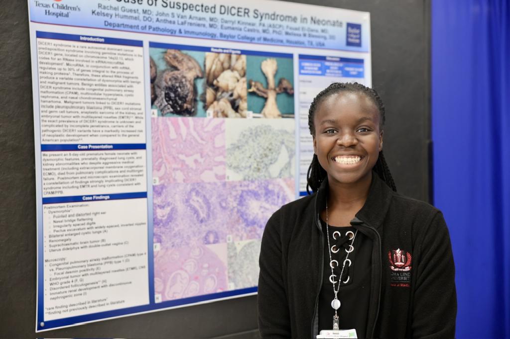 person smiling in front of a poster
