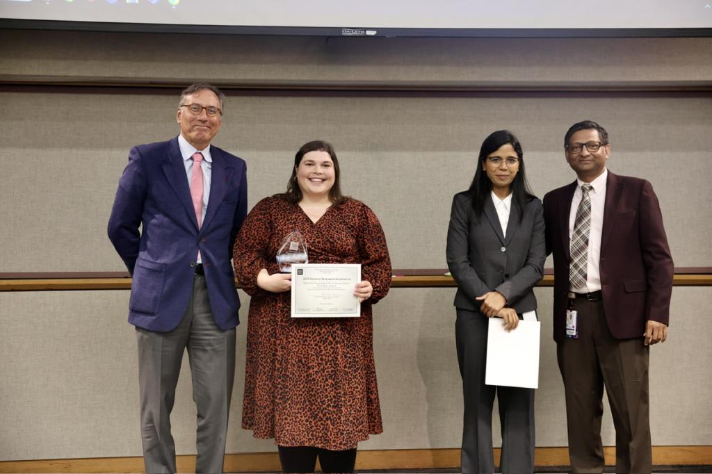 4 people smiling together and holding certificates