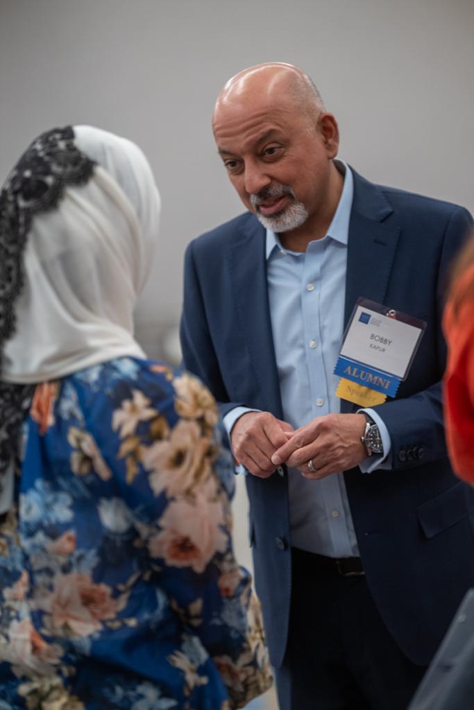 Inaugural director Dr. Bobby Kapur speaking happily to another person