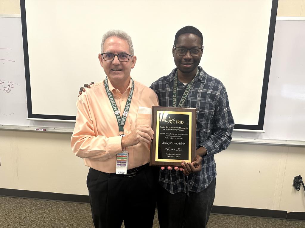 CTRID T32 Director, Dr. Rolando Rumbaut (left) presenting a graduation plaque to Dr. Ashley Payne (right).