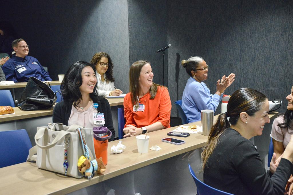 Smiling attendees cheer for a presentation
