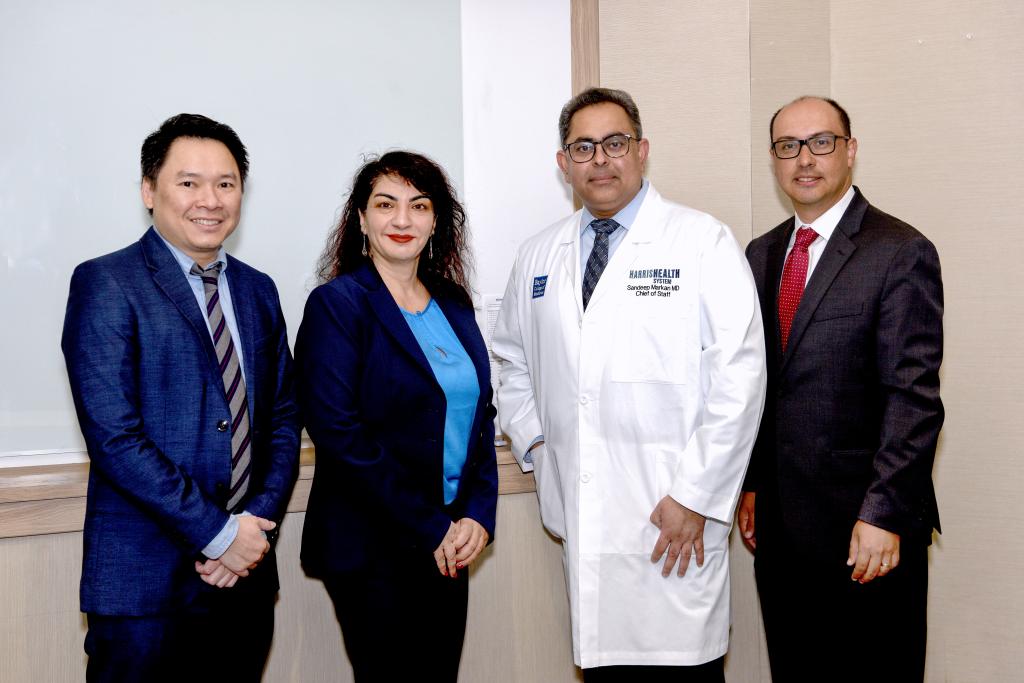 Four people smiling and posing after the conference.
