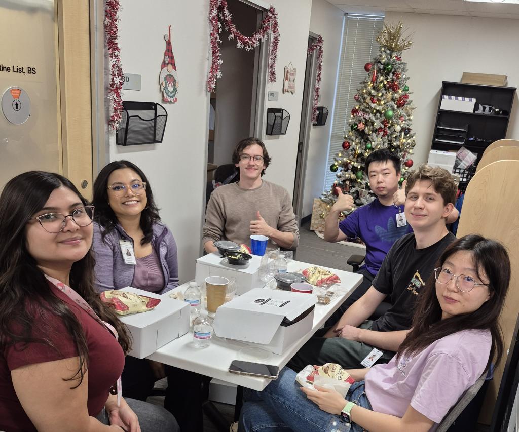 a small group of people smiling at a dinner table