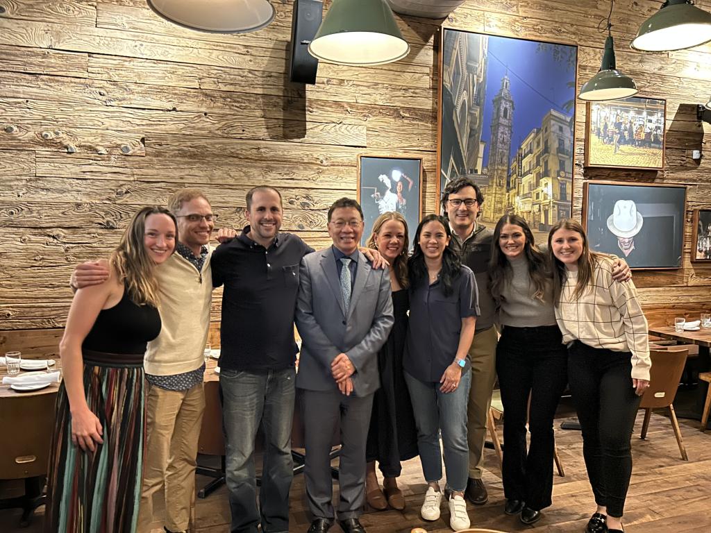 Several people posing together at a social event in a room full of cowboy-themed art.
